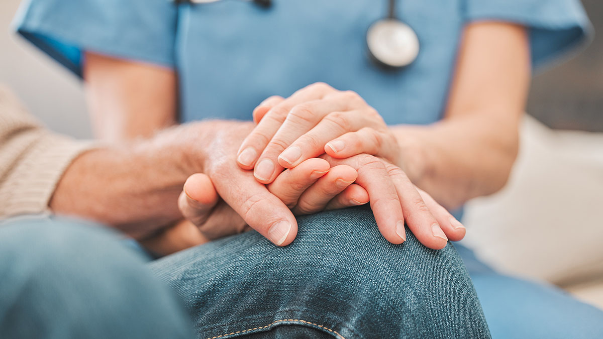 Close up image of a nurse's hands offering patient support